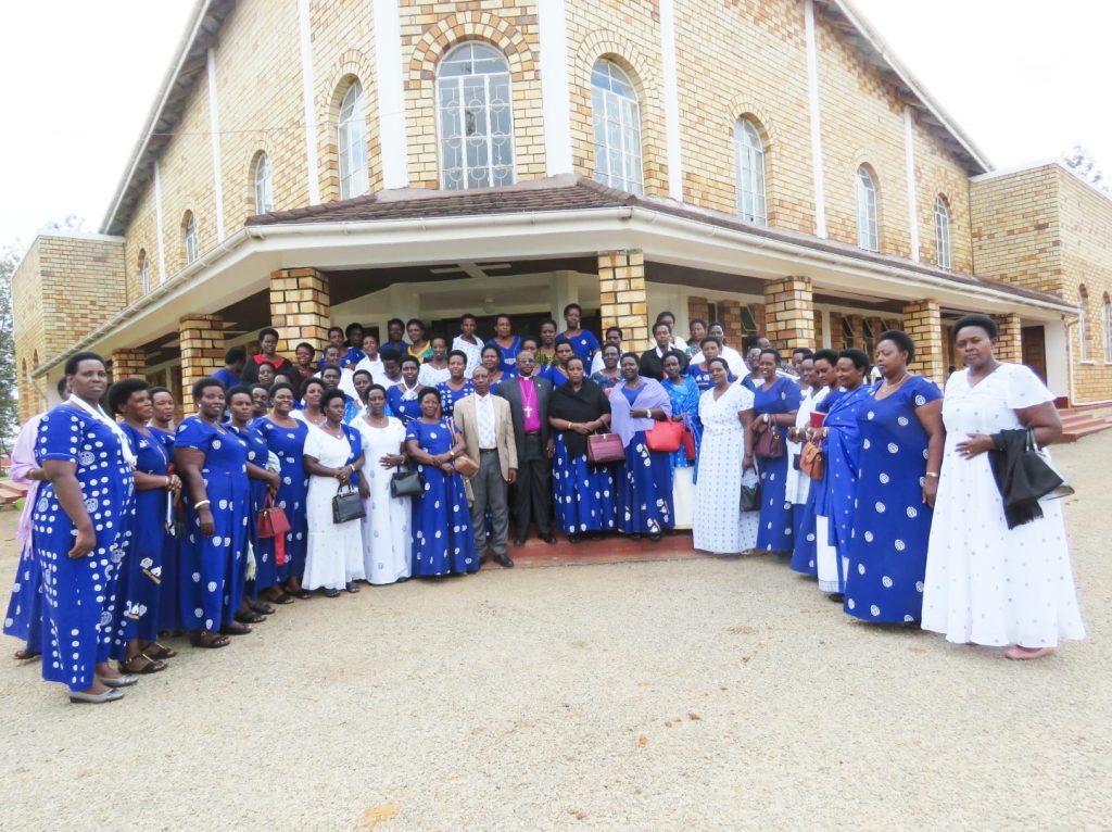 Rt. Rev Bishop Stephen Namanya and Mama Lydia Namanya in a black scarf with Members of North Ankole Diocese Mothers Union Council, posing for a group photo in front of Emmanuel Cathedral