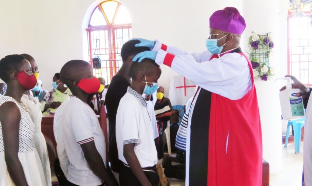 Rt. Rev. Bishop Stephen Namanya confirming young Christians into Anglican faith at Kanyanya parish.